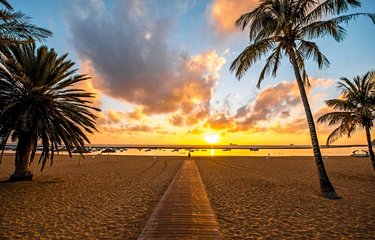 Coucher de soleil sur la plage de Las Teresitas, très appréciée des baigneurs avec ses palmiers et ses vagues tranquilles.