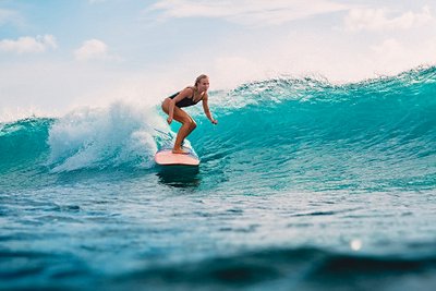 Surfeuse sur une vague polynésienne